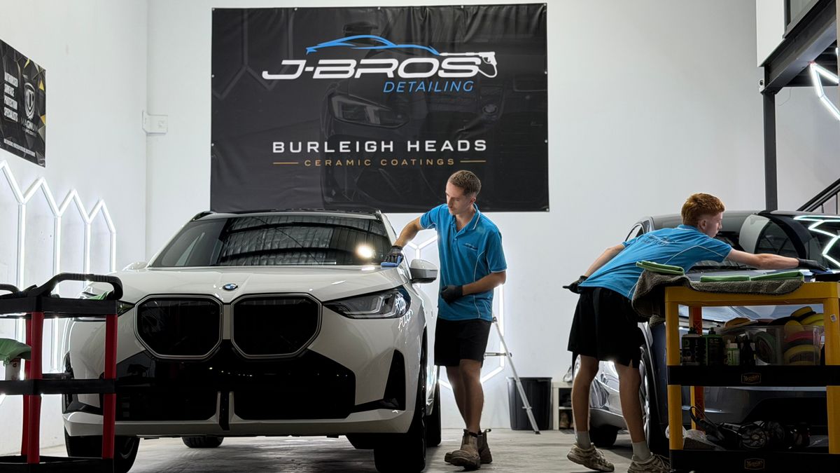 J-Bros detailers machine polishing a BMW iX during paint correction at the Burleigh Heads studio, ahead of ceramic coating