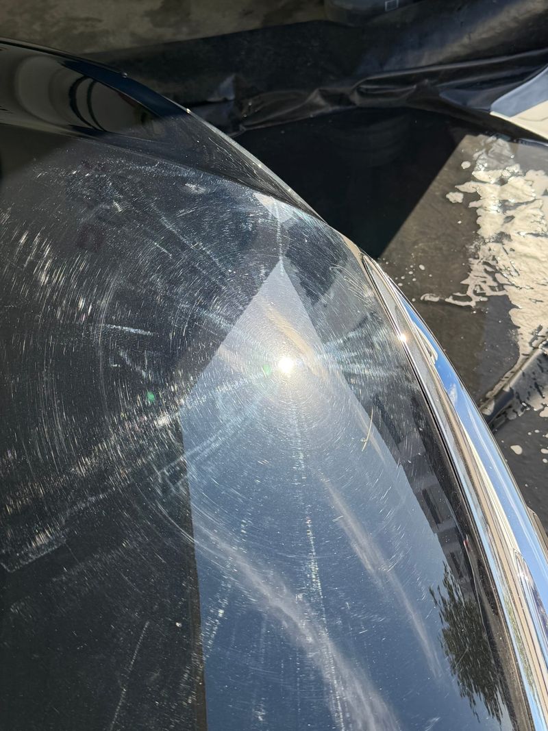 A black Mitsubishi Triton's paint covered in swirl marks and spider-webbing before a J-Bros paint correction on the Gold Coast